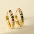 Detailed macro view of gold huggie hoop earrings featuring rainbow cubic zirconia inlay - Multicolor Hoop