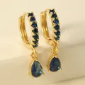 Close-up of golden hoop earrings with dark blue crystals and water drop pendants - Dark Blue Waterdrop
