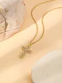 Detailed close-up of a gold-plated stainless steel cross necklace featuring rhinestones. - Cross Style 1 W1501