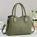 Elegant green litchi grain leather handbag with gold accents and adjustable strap - Green