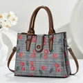 Gray canvas tote bag with cherry print and brown leather straps in a minimalist setting - Gray
