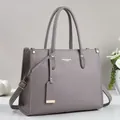 Grey pebbled leather tote bag with dual handles and adjustable strap for daily use - Gray