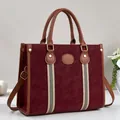 Detailed shot of burgundy tote bag featuring striped webbing and textured faux leather - Burgundy
