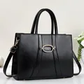 Classic black leather handbag with gold buckle and adjustable shoulder strap for women - Black