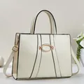 Close-up of cream white handbag featuring a gold oval clasp and premium texture - Off White