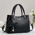 Bolso negro con patrón de lichi, colgante de lazo con perla y herrajes plateados - Negro