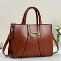 Close-up of brown vintage handbag with gold oval hardware and detailed leather texture - Earthy Yellow