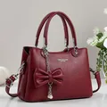 Bolso de mano color burdeos en cuero con adorno de lazo y perla, diseño elegante - Rojo