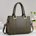 Detail of olive green tote bag featuring woven texture accents and gold-tone metal hardware - Green