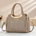 Detail of elegant beige handbag featuring gold metal hardware and vertical leather texture - Khaki