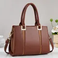 Close-up of premium brown leather tote bag with stitch textures and gold hardware details - Earthy Yellow