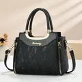 Detailed macro view of black textured leather handbag with gold curved metal handles - Black
