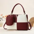 Detail of color-block burgundy handbag with V-shaped metal hardware and litchi texture - Burgundy