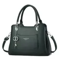 Detail of black lychee leather handbag with Fashion Queen text and pearl metal charm - Green