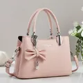 Rosa Handtasche mit Litschi-Struktur, Perlenbogen und verstellbarem Schultergurt - Rosa