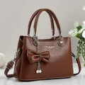 Braune Damen Handtasche aus Leder mit Litschimuster, Schleife und Perlenanhänger - Erdgelb