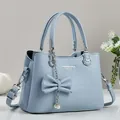 Detailansicht hellblaue Lederhandtasche mit großer Schleife und Perlen Metallkette - Blau