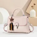 Detail of pink leather handbag with silver rotary lock and colorful star bead pendant - Pink