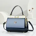 Elegant navy blue patent leather handbag with gold-tone hardware and top handle - Glossy Patent Style / Blue