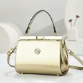 Luxurious gold metallic handbag with metal frame and adjustable crossbody strap - Glossy Patent Style / Gold