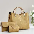 Détail d'un ensemble de 3 sacs dorés montrant le cuir synthétique texturé et logo métal - 23cmx11cmx19cm / Sac à Main Avec Pochette Et Bourse / Or