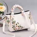 Elegante borsa a mano color crema con ricamo floreale e manico intrecciato - Bianco