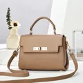 Detail of trendy khaki crossbody bag featuring lychee texture and gold metal twist lock - Khaki