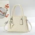Ivory quilted leather handbag with star pendant, double handles, and crossbody strap - White