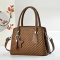Detail of a brown quilted handbag with star pendant and textured leather stitching - Khaki