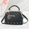 Quilted black pillow bag with gold Danbaoly logo and elegant heart charm on a pedestal - Black