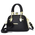 Detail of black faux leather shell bag with gold frame and diamond-shaped clasp - Black