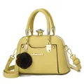 Detail of light yellow leopard-print shell bag with gold hardware and rose charm - Yellow