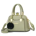 Detail of light green shell bag with gold metal frame, floral charm and logo - Light Green