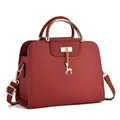 Dettaglio della borsa in pelle bordeaux con manico dorato e ciondolo a forma di cervo - Stile Pendaglio Cervo / 26cm x 10cm x 18cm / Rosso ciliegia