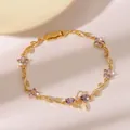 Goldenes Rebenarmband mit lila Zirkon-Schmetterlingsschleife und floralen Akzenten - Lila Blumen- und Schleifen-Armband-Stil (DQ-W-3395)