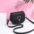 Fashionable black matte saddle bag with white contrast stitching and gold cat-ear buckle - Black