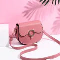 Pink PU leather saddle bag with round cat buckle and white decorative stitching details - Pink