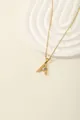 Macro detail of gold letter A pendant with blue stone and sparkling zircons on fine chain - Letter A