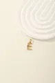 Close-up of golden letter E pendant with blue and white zircon stones and sunburst texture - Letter E
