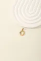 Detail of gold letter O pendant with sparkling blue and white zircon stones inlay - Letter O