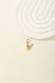 Macro detail of gold V-letter pendant with light blue gemstone and zircon inlay - Letter V
