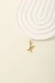 Detailed macro of a gold letter X pendant featuring a blue center stone and zircon accents - Letter X