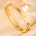 Detail of gold minimalist bangle with star engravings and embedded zircon stones - Brushed Star Alternating Zirconia / Gold