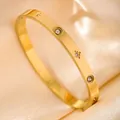 Macro shot of gold brushed bangle featuring star-patterned white zircon inlay on silk - Brushed Round Engraved Zirconia / Gold