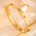 Detail of gold-plated brushed metal bangle featuring sparkling crystals in petal settings - Brushed Petal Base Zirconia / Gold