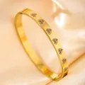 Detail of gold heart engraved bangle with cubic zirconia on luxury silk background - Engraved Heart Three Zirconia / Gold