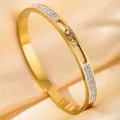 Gold bangle with three sliding zircons in a hollow track on silk background - DQ-2445-3 (Sliding Diamond Style)