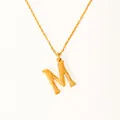 Detail of 18k gold plated letter M pendant with textured surface and fine link chain - Letter M