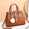 Quilted caramel PU leather handbag with V-shaped stitching and plush pearl charm - Earthy Yellow