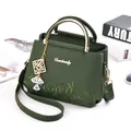Donkergroene crossbodytas met bloemenborduurwerk en gouden metalen handvat op bureau - 21*11*17cm / Groen